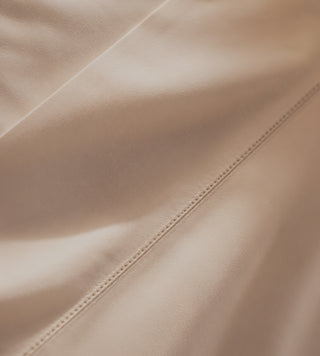 Close-up of champagne sateen sheets.