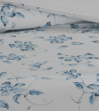 White bedding with a blue floral print.
