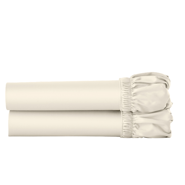 Two ivory cotton fitted sheets folded and stacked.