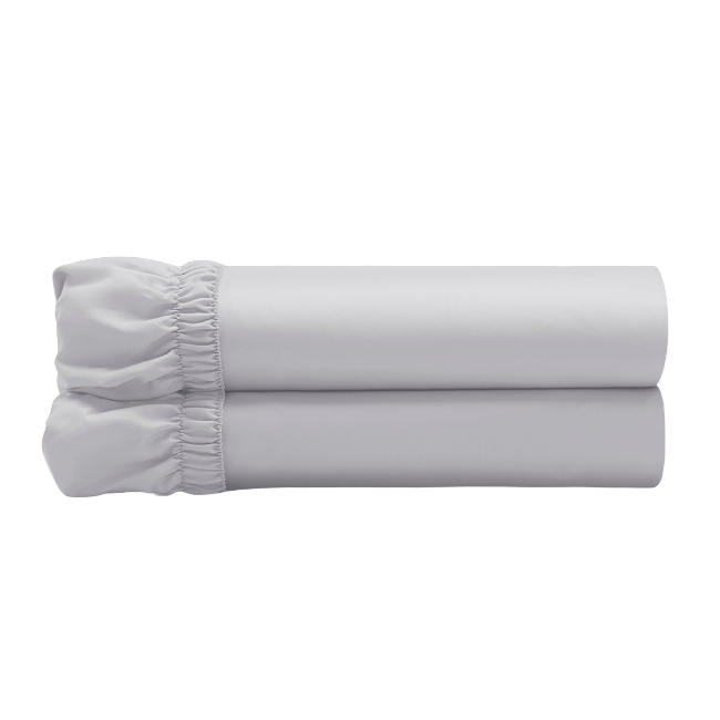 Light grey fitted sheets folded and stacked, showing gathered elastic edges.