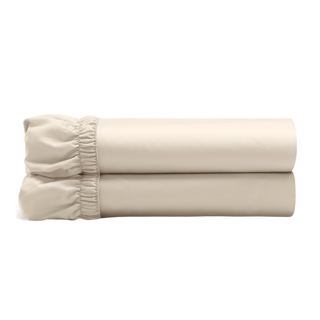 Beige fitted sheets folded and stacked, showing gathered elastic edges.