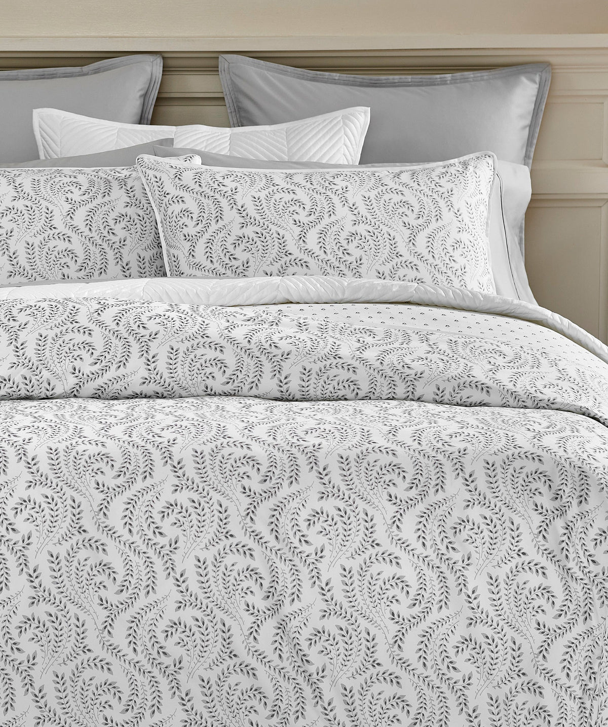 Layered grey and white botanical duvet cover set styled on a bed.