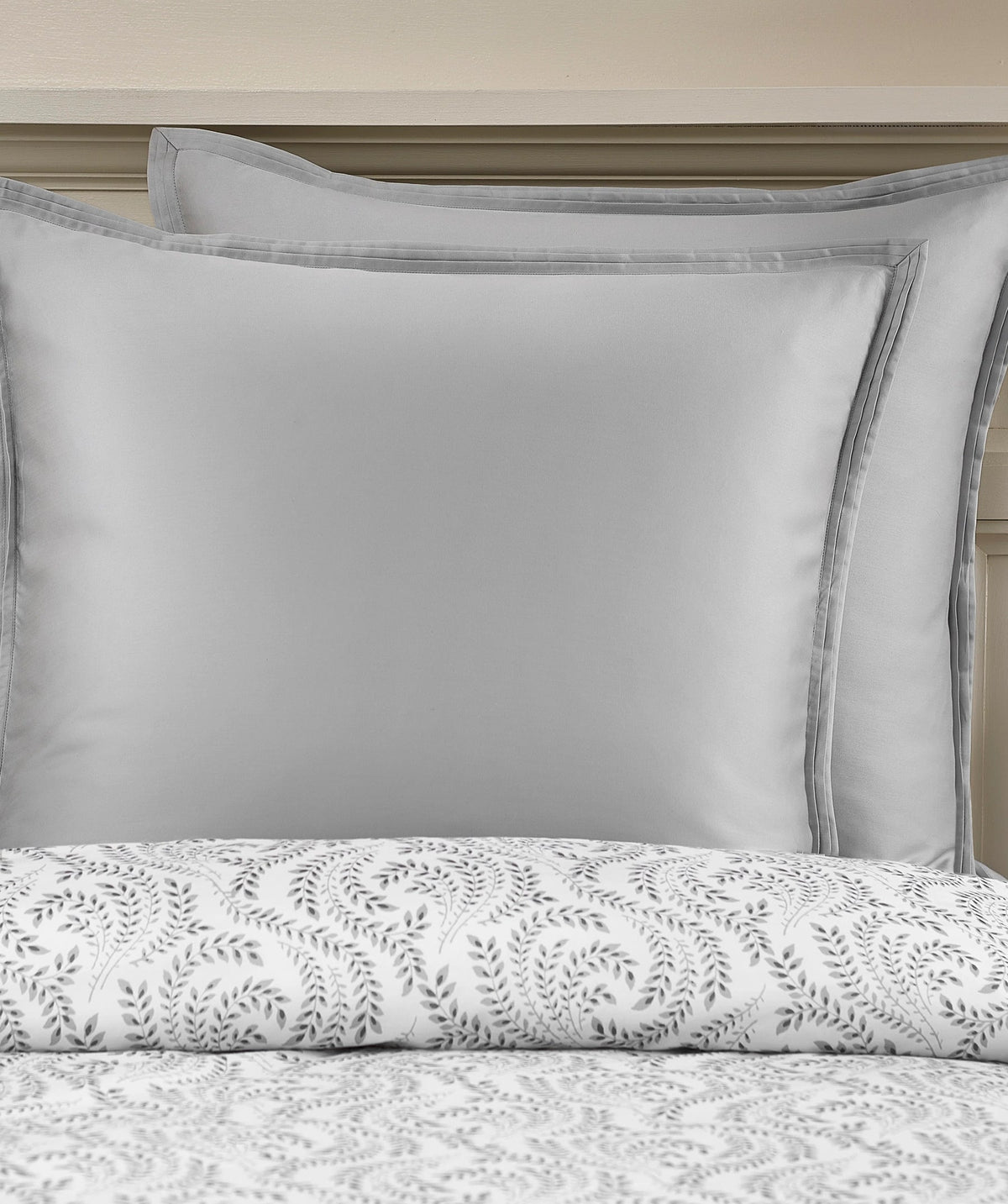 Grey border pillow shams layered with the botanical duvet cover set.