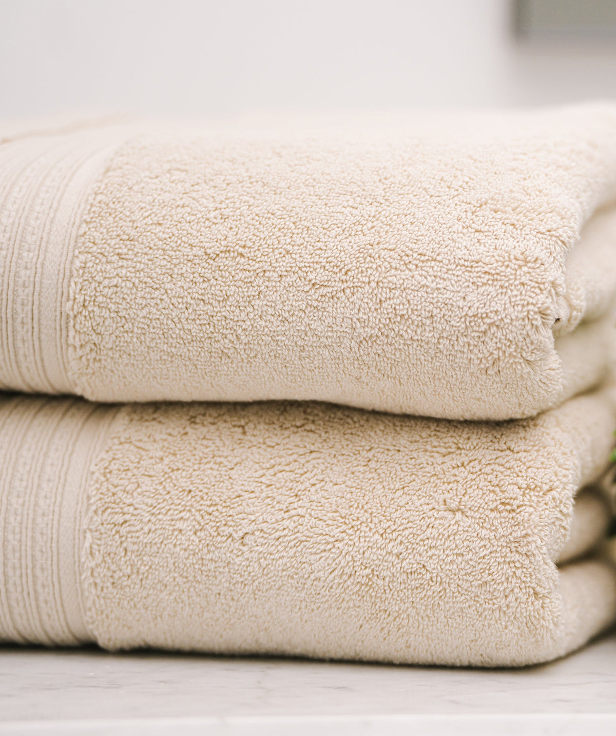 Close-up of stacked beige bath towels.