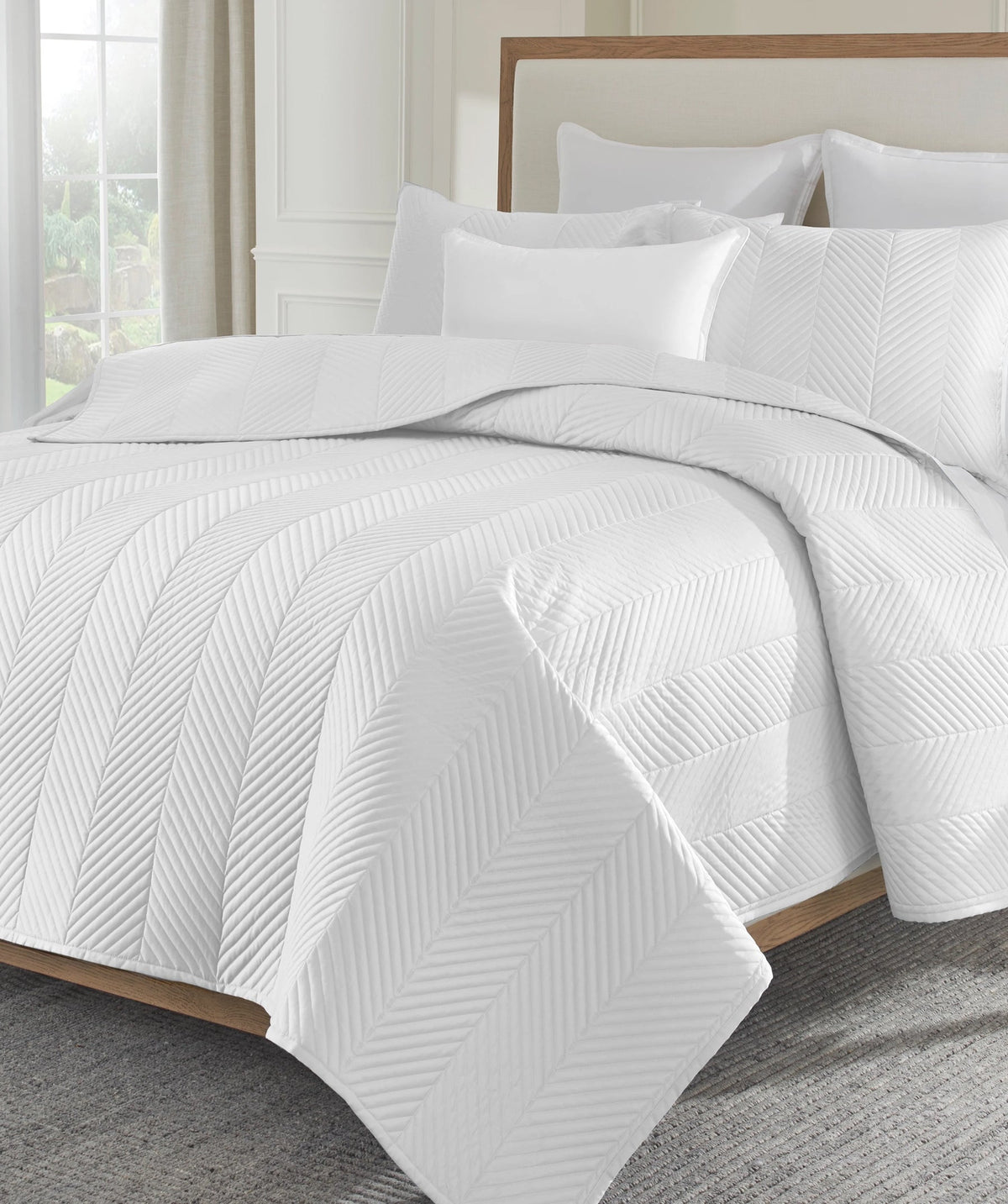 White herringbone stitch coverlet set styled on a bed.
