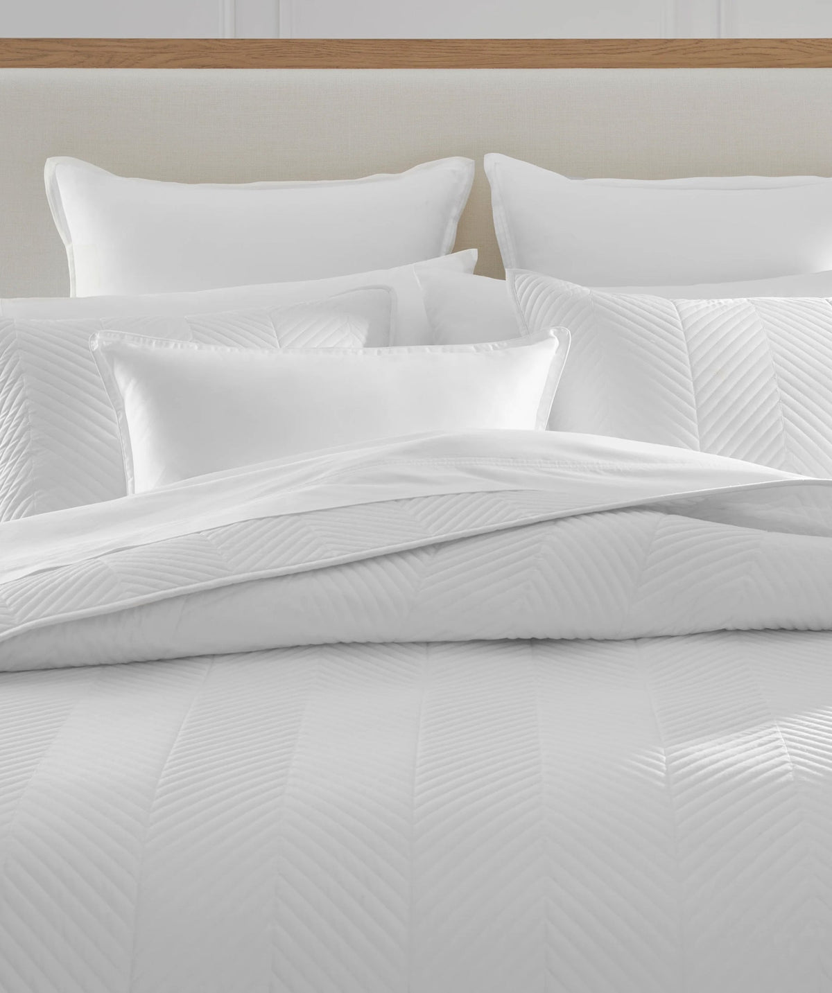 White herringbone stitch coverlet set styled on a bed.
