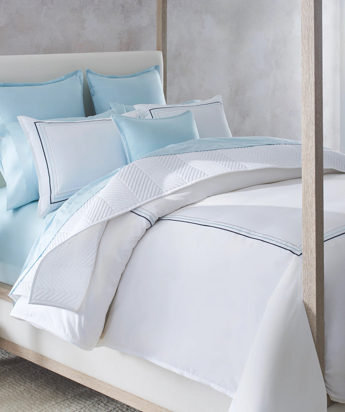White embroidered border duvet cover set styled on a bed.