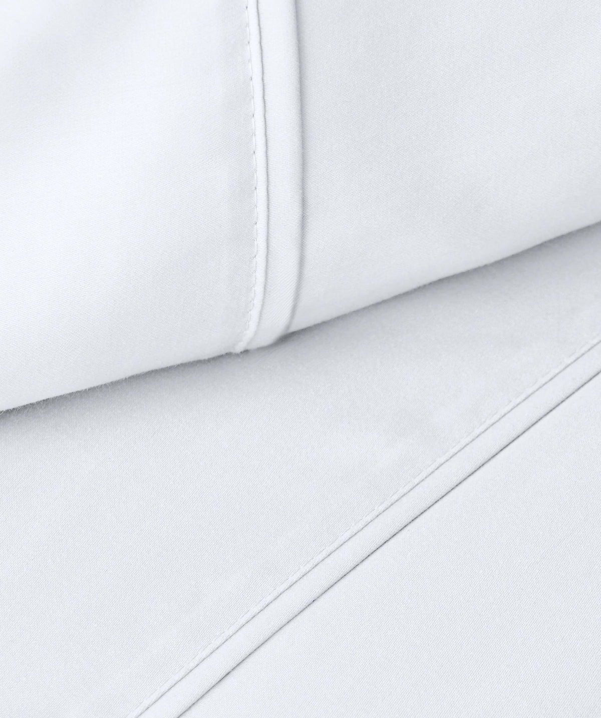 Close-up of white pillowcase fabric with stitched hem details.
