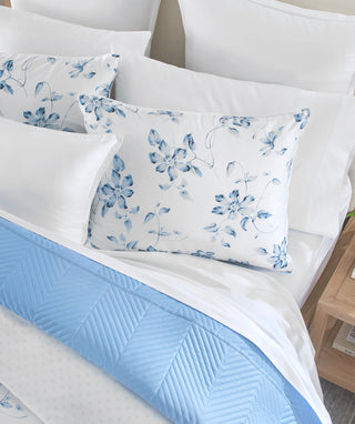 Layered blue floral duvet cover set with coordinating blue bedding.