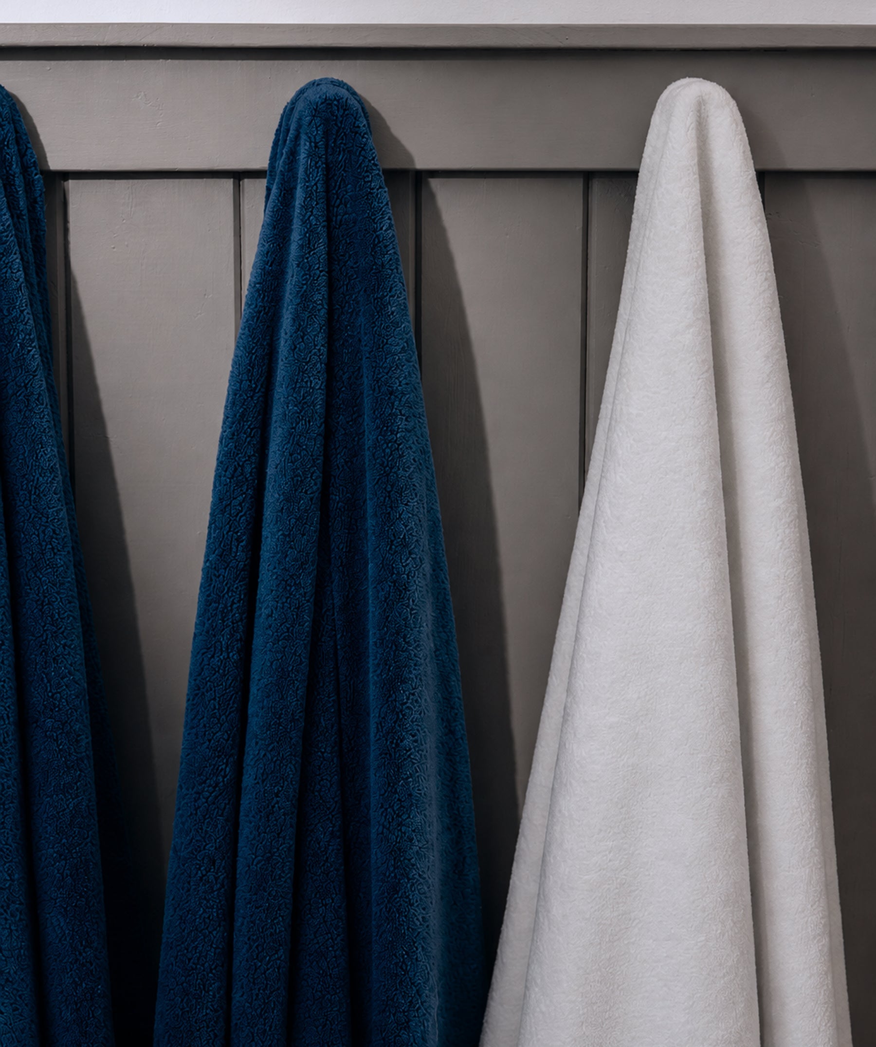 Navy and white bath sheets hanging side by side.