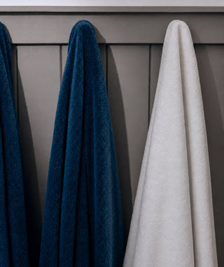 Navy and white bath sheets hanging side by side.