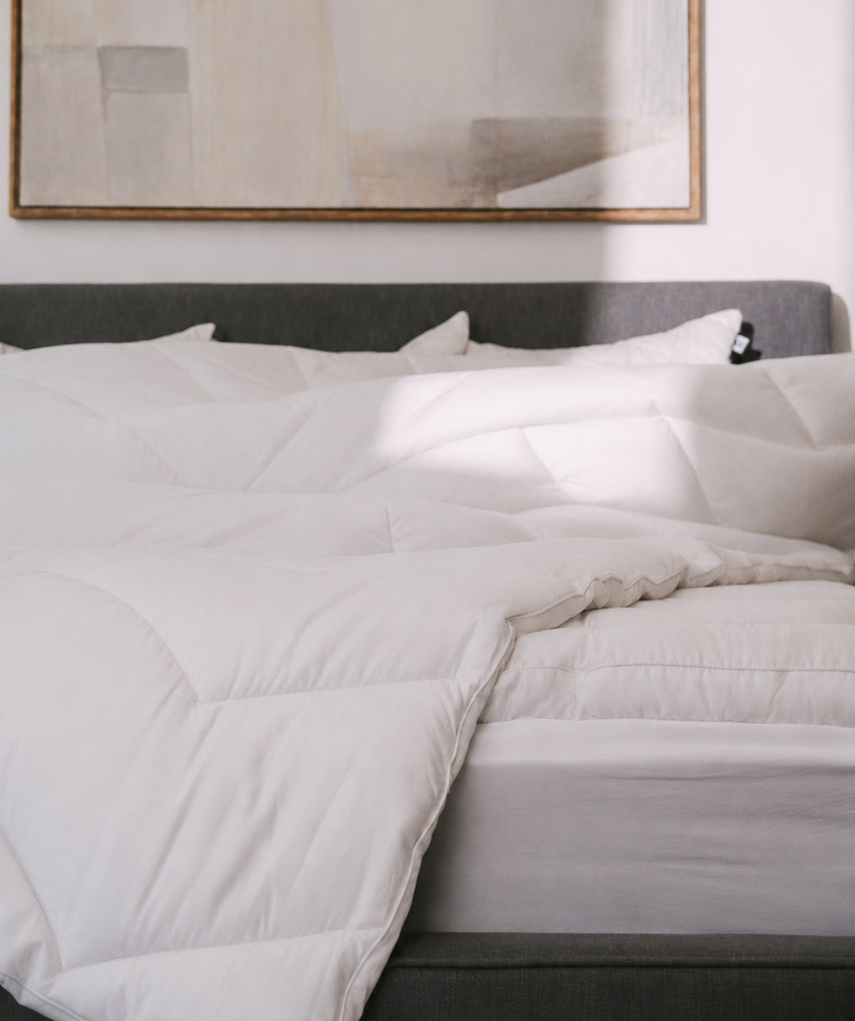 White comforter styled on a bed.