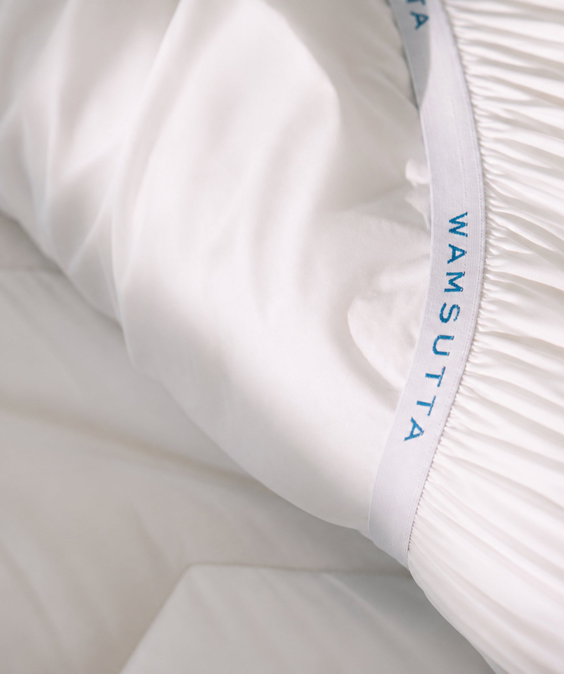 Close-up of mattress topper with elastic fitted egde.
