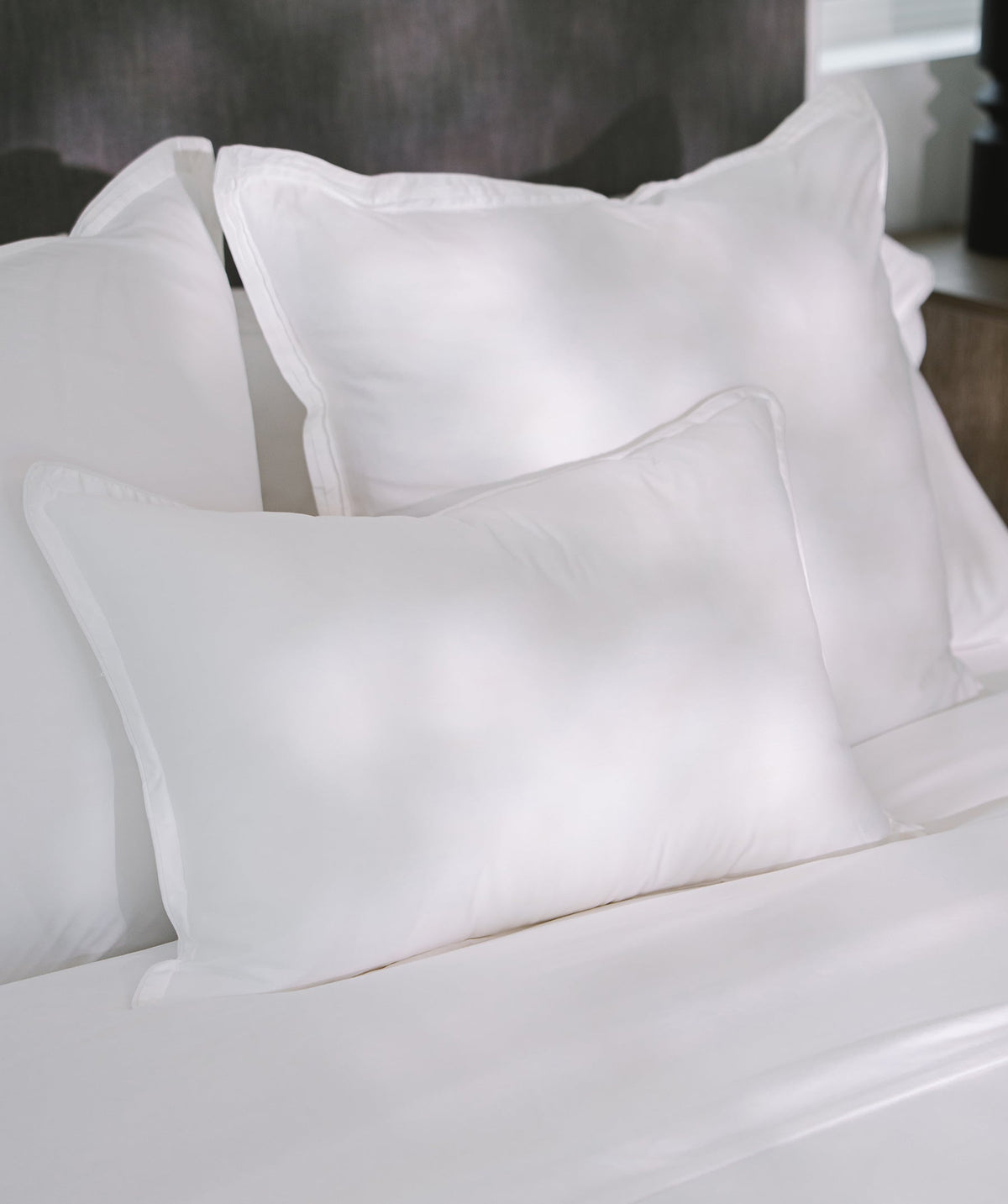 White bolster pillow styled on a bed.