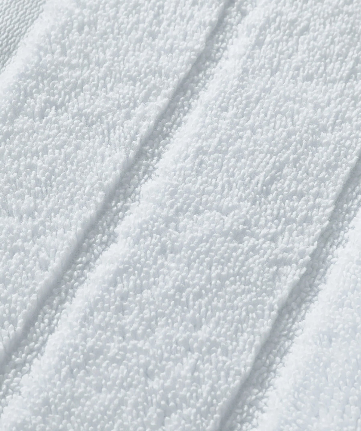 Close-up of plush white Egyptian cotton bath towel texture.