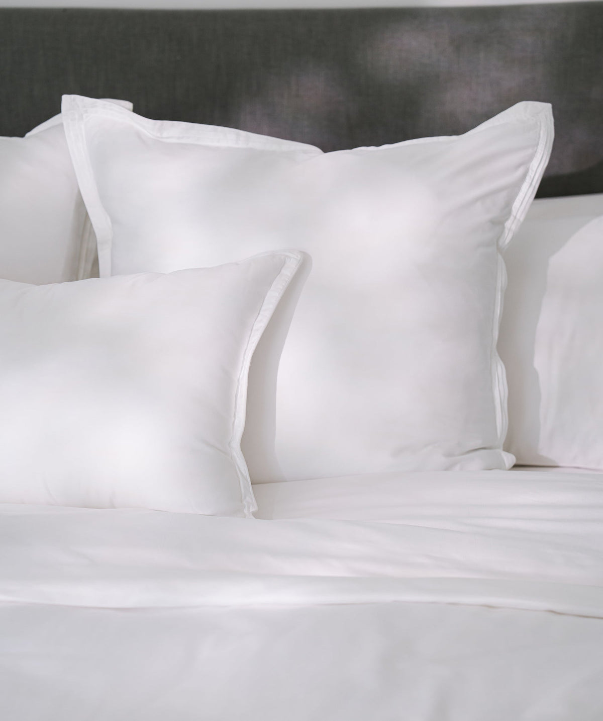White solid Euro shams styled on a bed.