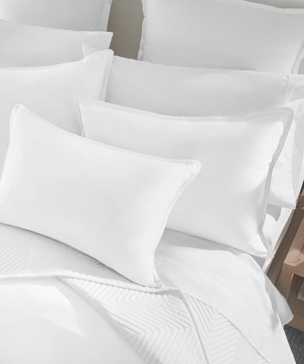 White comforter set styled on a bed with matching pillow shams and decorative pillows.
