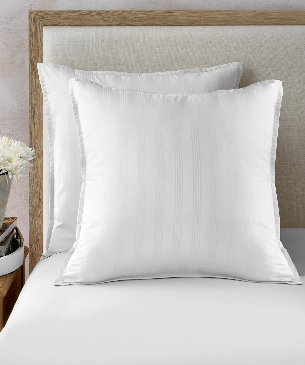 White striped Euro shams styled on a bed.