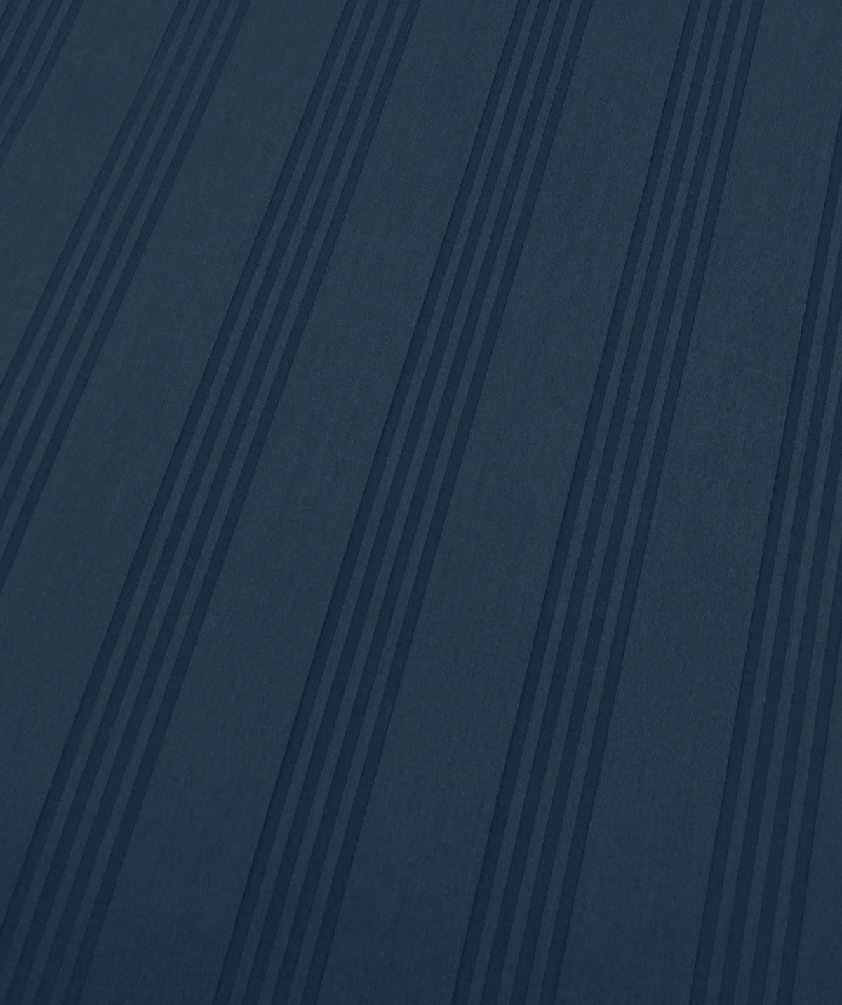 A close-up of a dark navy blue textured material with vertical pinstripes.