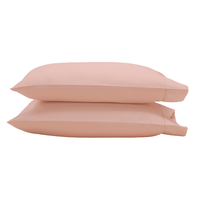 Two peach pillowcases stacked on top of each other.