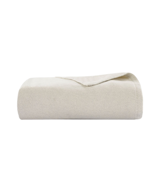 A folded cream-colored woven textile, likely a blanket or throw, shown on a solid white background.